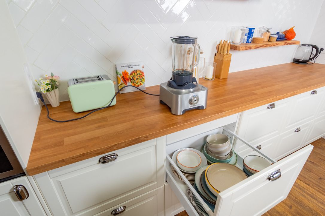 Plan de travail en bois du studio avec blender, grille-pain et tiroir de vaisselle ouvert